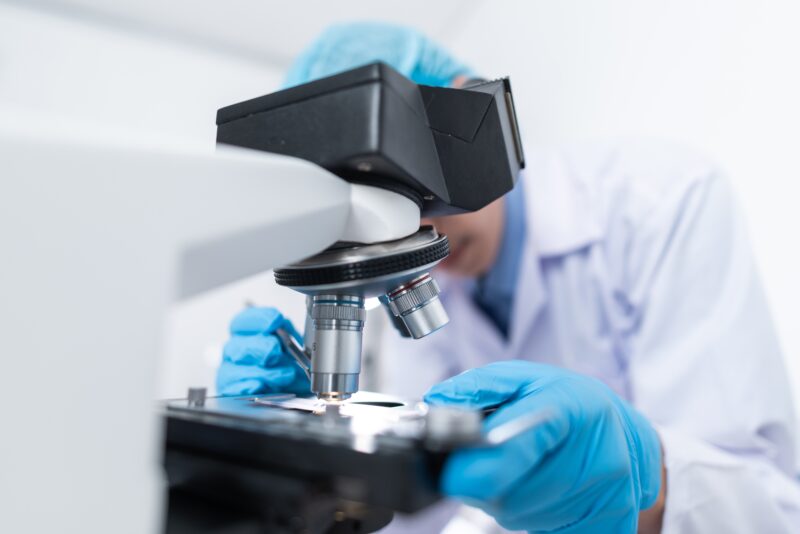 Lab researcher observing blood sample through a microscope