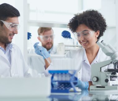 Three researchers in lab smiling
