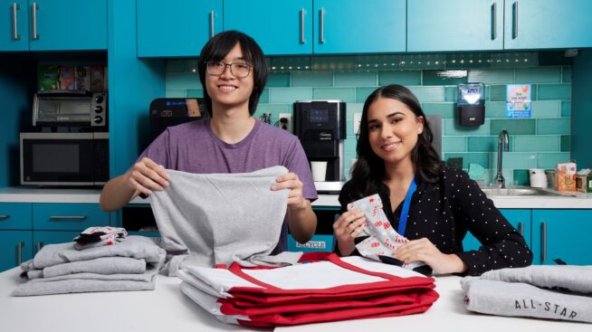 Two volunteers folding Rhode Island Blood Center shirts as gifts for donors