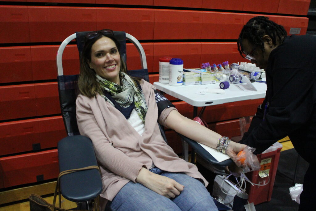 A smiling blood donor being attended to by BBD phlebotomist.