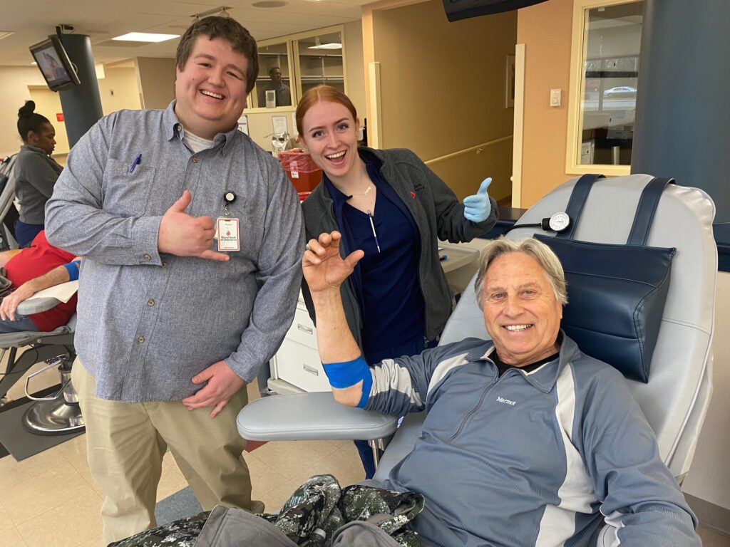 Two smiling blood donors with BBD staff member.