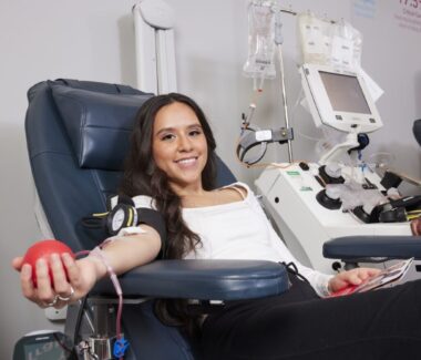 Smiling blood donor with a red ball in her hand